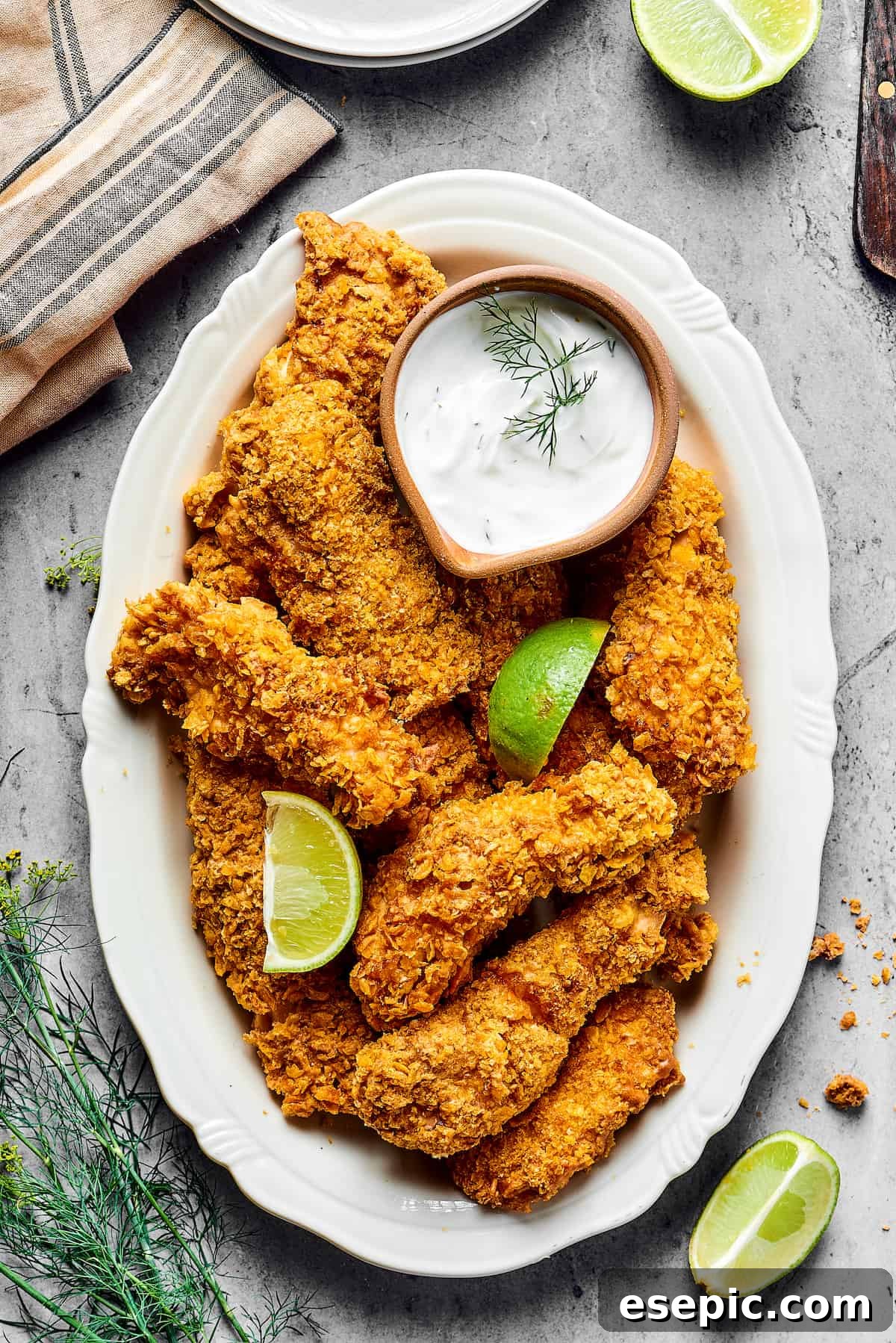 Utterly addictive, this easy recipe for Air Fryer Chicken Tempura is a favorite! Tender, juicy chicken strips are coated in a light and crispy batter, and then air-fried to golden perfection. Air-fried chicken pieces on a platter garnished with lime wedges and a small dish of dipping sauce.