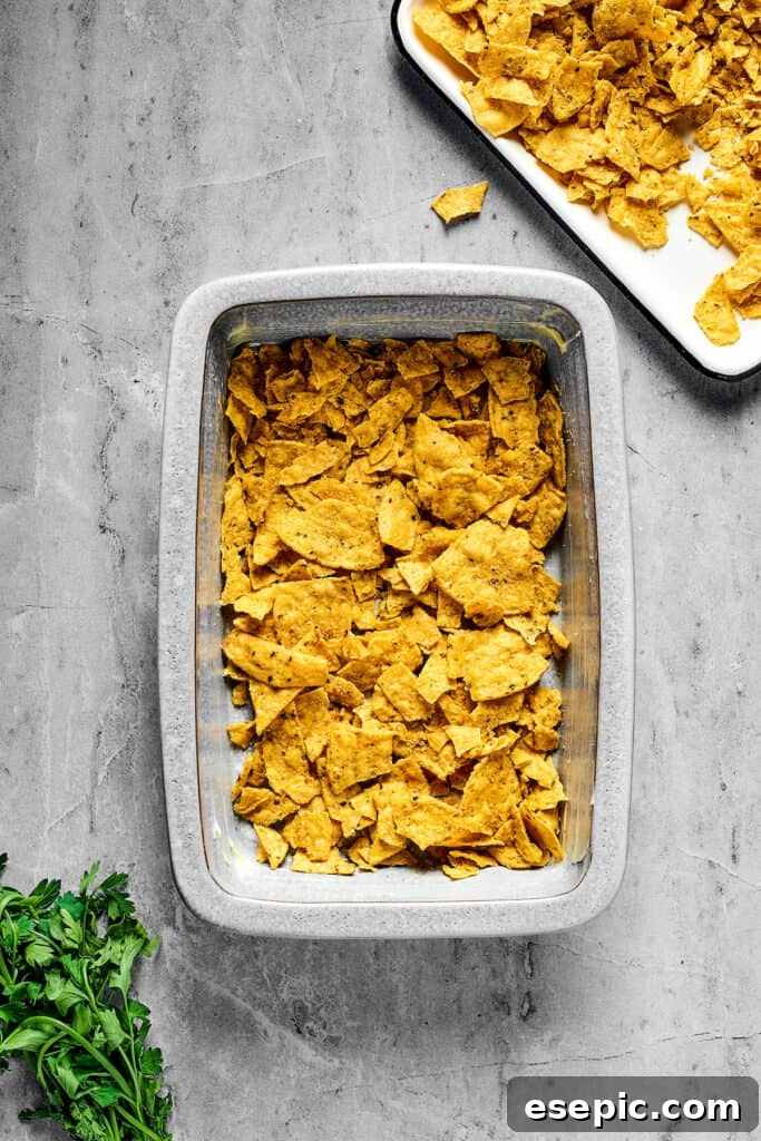 A baking dish with corn chips layered in the bottom.
