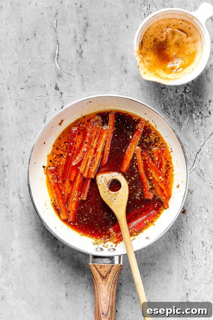 Bell pepper strips cooking in a skillet of reddish sauce.