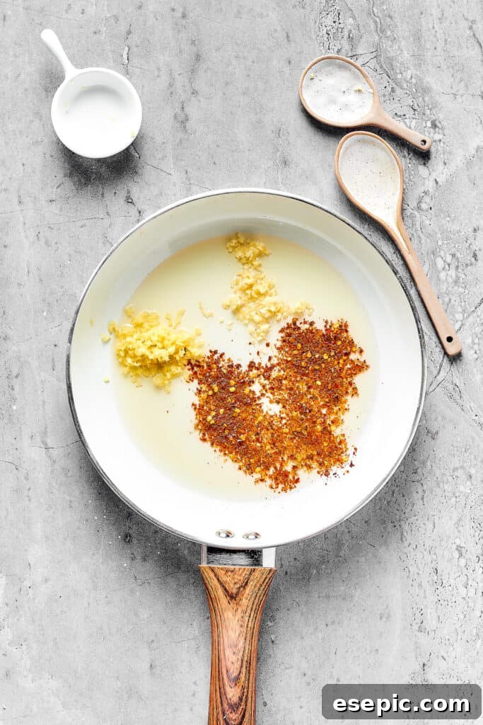 Spices and aromatics in a skillet.