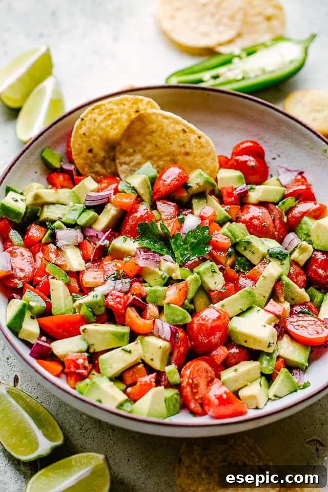 Fresh avocado salsa served with golden tortilla chips and lime wedges, ready for a festive celebration.