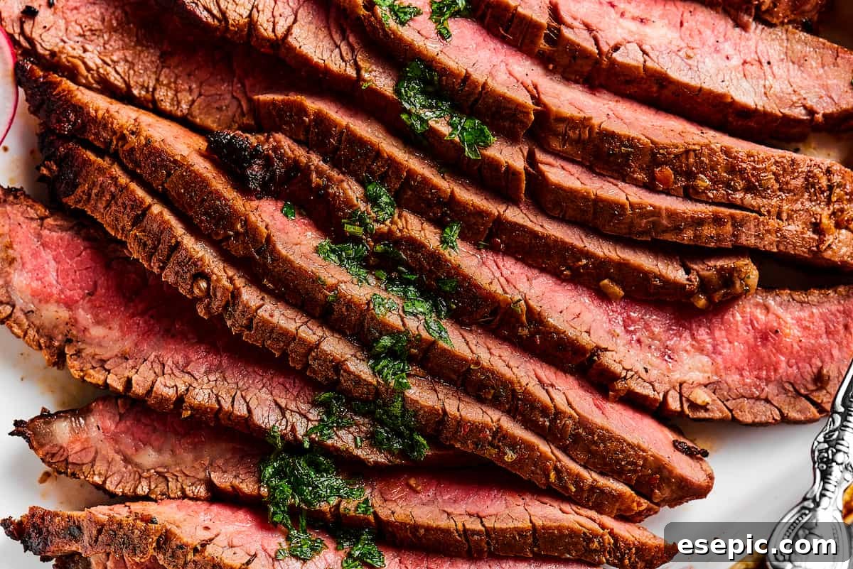 Orange and lime juice, garlic and jalapeno, maple and cumin - this easy Grilled Carne Asada is drenched in a medley of mouthwatering flavors! Close up shot of perfectly sliced flank steak, revealing its attractive medium-rare doneness and tender texture.