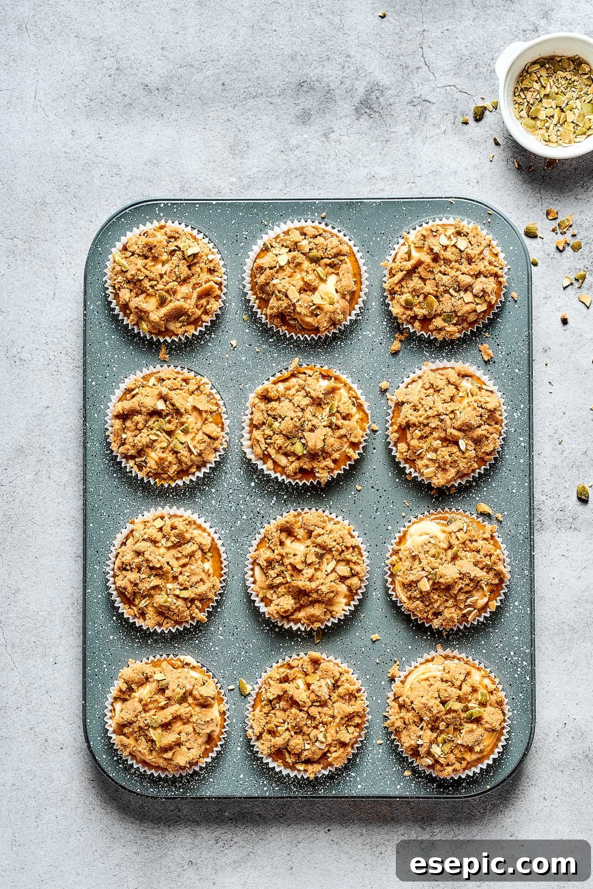 Pumpkin Cream Cheese Muffins are a heavenly mix of spiced pumpkin cake and smooth cream cheese swirl, with a buttery, streusel-like topping. Pumpkin cream cheese muffins freshly baked and cooling in a muffin tin.