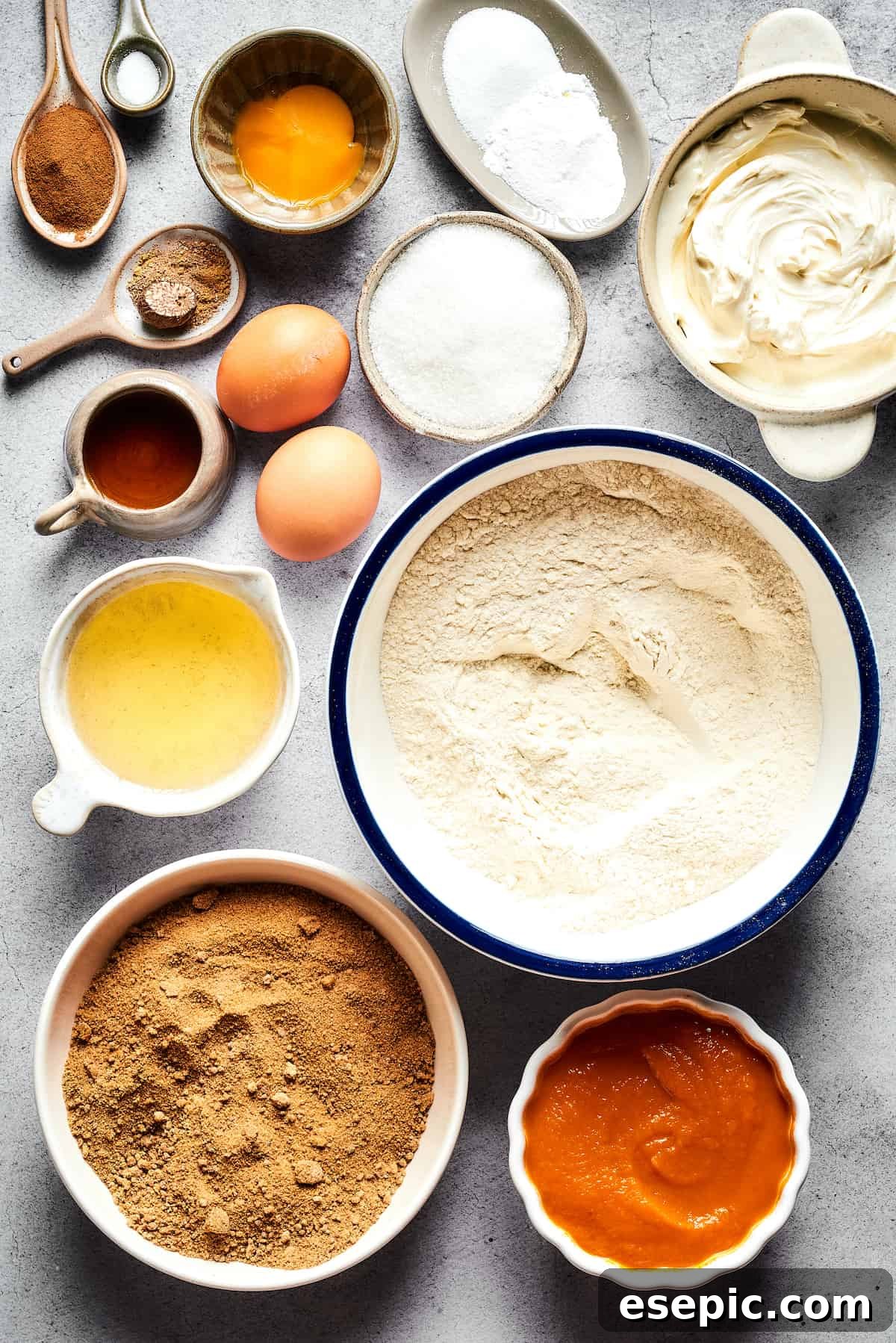 Pumpkin Cream Cheese Muffins: a heavenly mix of spiced pumpkin cake and smooth cream cheese swirl, with a buttery, streusel-like topping, made from these key ingredients. Ingredients for Pumpkin Cream Cheese Muffins laid out on a surface, including cinnamon, salt, eggs, cream cheese, sugars, oil, flour, and pumpkin puree.