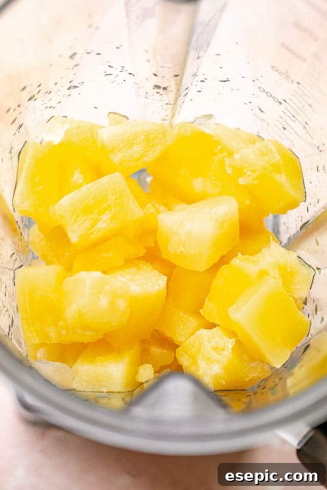 Sun-Kissed Pineapple Margaritas 3 Pineapple chunks in a blender, ready to be transformed into a delicious margarita.