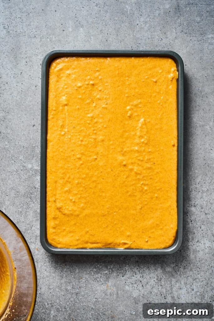A baking dish filled with the smooth, orange pumpkin cheesecake filling.