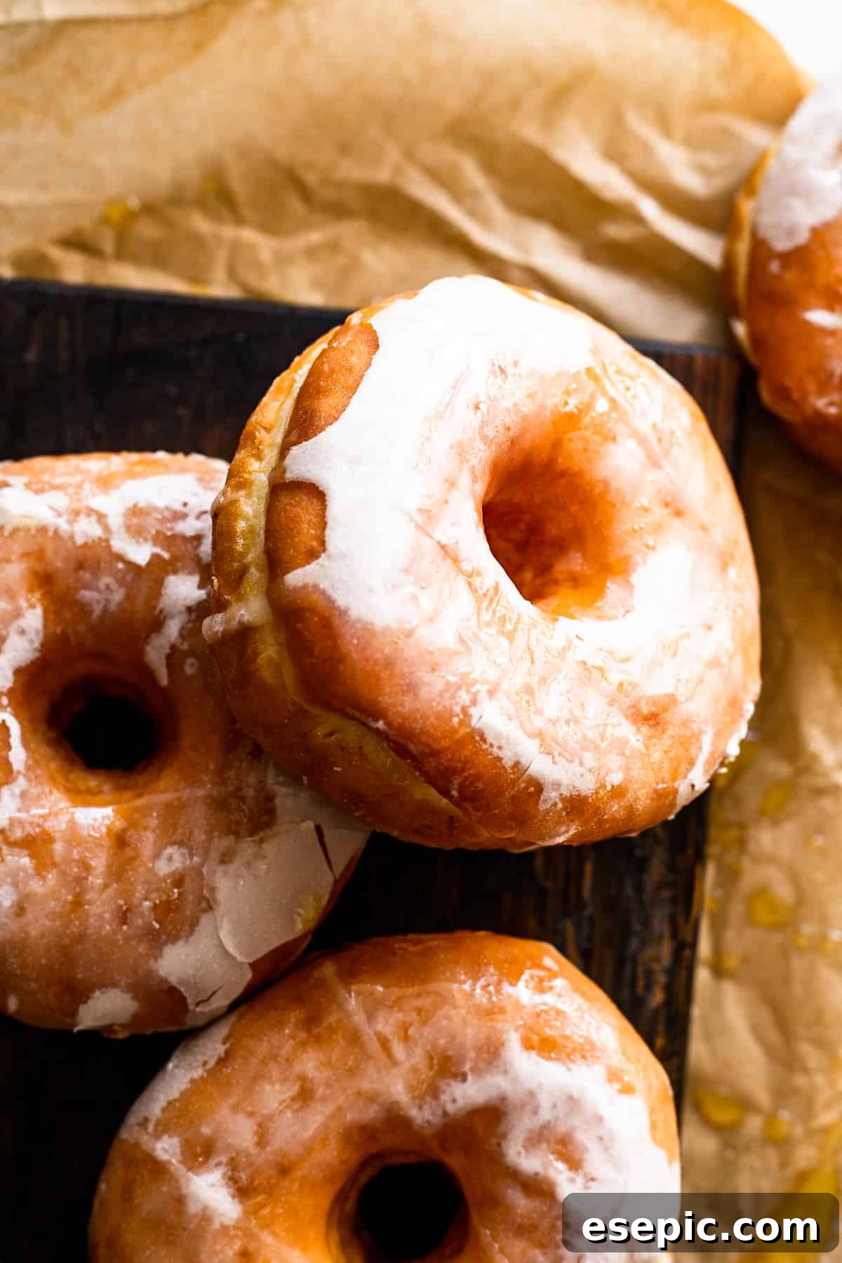 Cozy Baked Apple Cider Doughnuts with Maple Drizzle 3 close-up view of maple glazed apple cider doughnuts resting on a rustic wooden board, ready to be enjoyed.