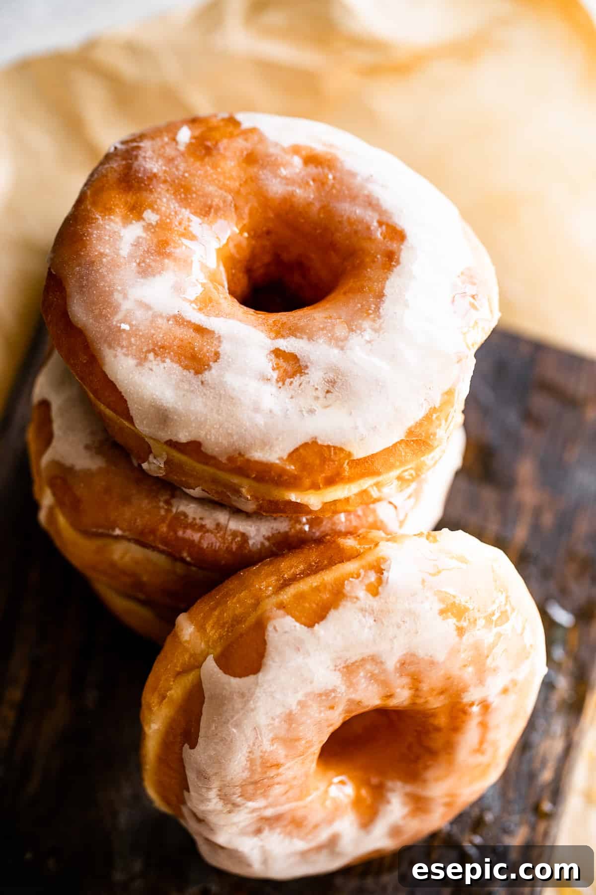 Cozy Baked Apple Cider Doughnuts with Maple Drizzle 7 overhead shot of stacked up baked apple cider doughnuts, beautifully glazed, set on a warm brown backdrop, ready to be enjoyed or stored.