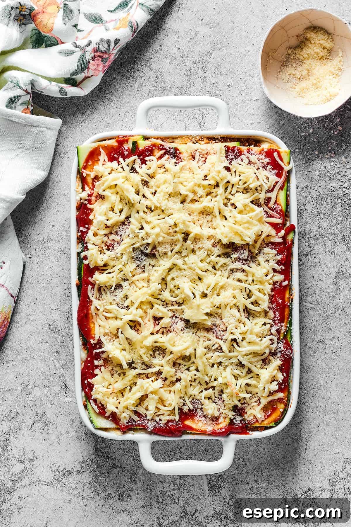Savory Layered Zucchini Beef Lasagna 10 A lasagna prepared for baking, topped generously with shredded mozzarella cheese, promising a golden, bubbly crust.