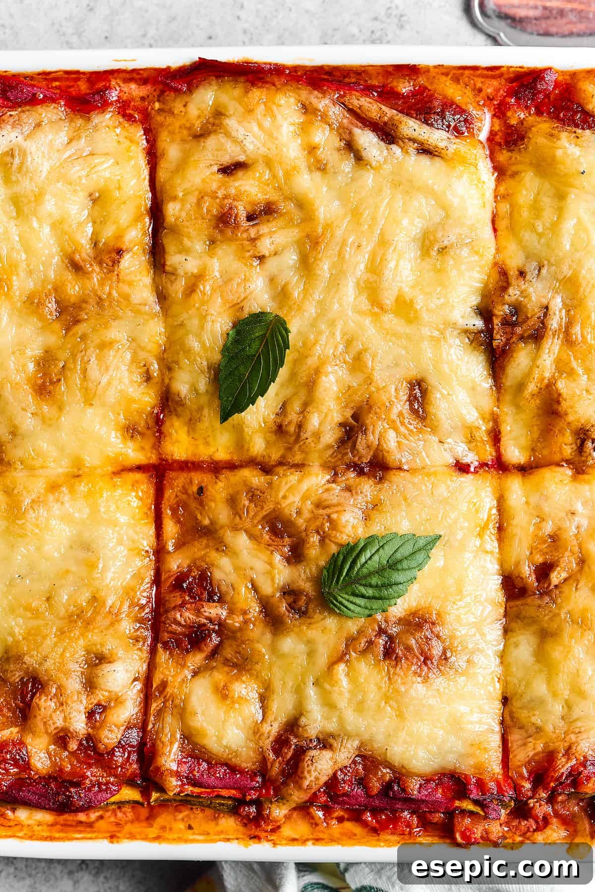 Comforting Zucchini Lasagna with meat sauce is the perfect low-carb family meal. Cheesy, saucy, and healthy, with zucchini instead of pasta! A close-up shot of a pan of freshly baked zucchini lasagna, expertly cut into large, inviting squares.