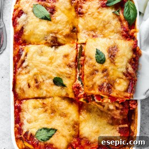 Savory Layered Zucchini Beef Lasagna 11 A slice of zucchini lasagna being lifted from a baking dish.