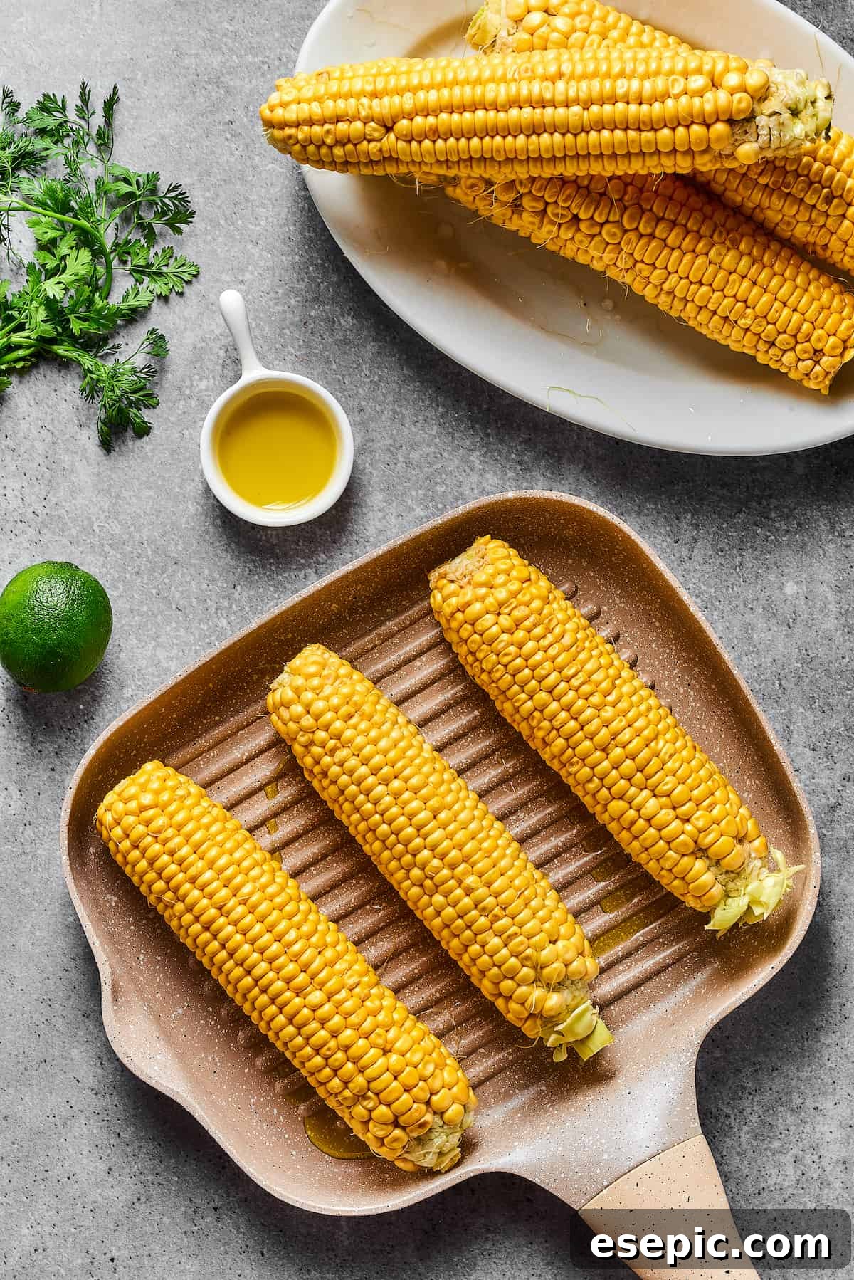 Mexican Street Corn Salad is a mouthwatering dish that’ll have everyone begging for the recipe! Fresh corn kernels in a killer creamy sauce. Ears of corn cooking on a grill pan.