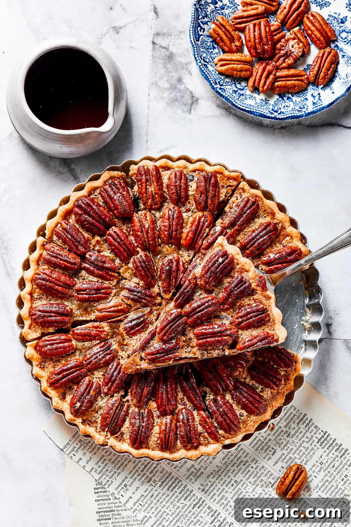 A perfectly baked slice of pecan pie, glistening with sweet maple filling, being lifted from the whole pie with a server, ready to be enjoyed.