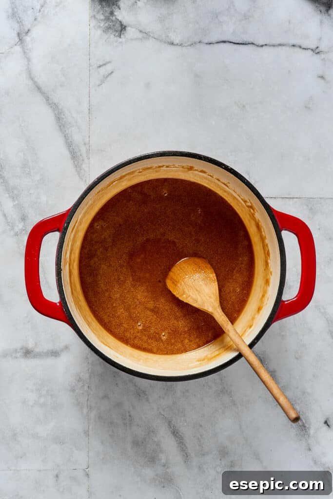 A glistening sugar-syrup mixture simmering in a saucepan on the stovetop, just after the sugar has dissolved, ready to be cooled.