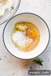 Preparing the yogurt mixture for chicken tenders, showing a bowl with yogurt, egg, and seasonings
