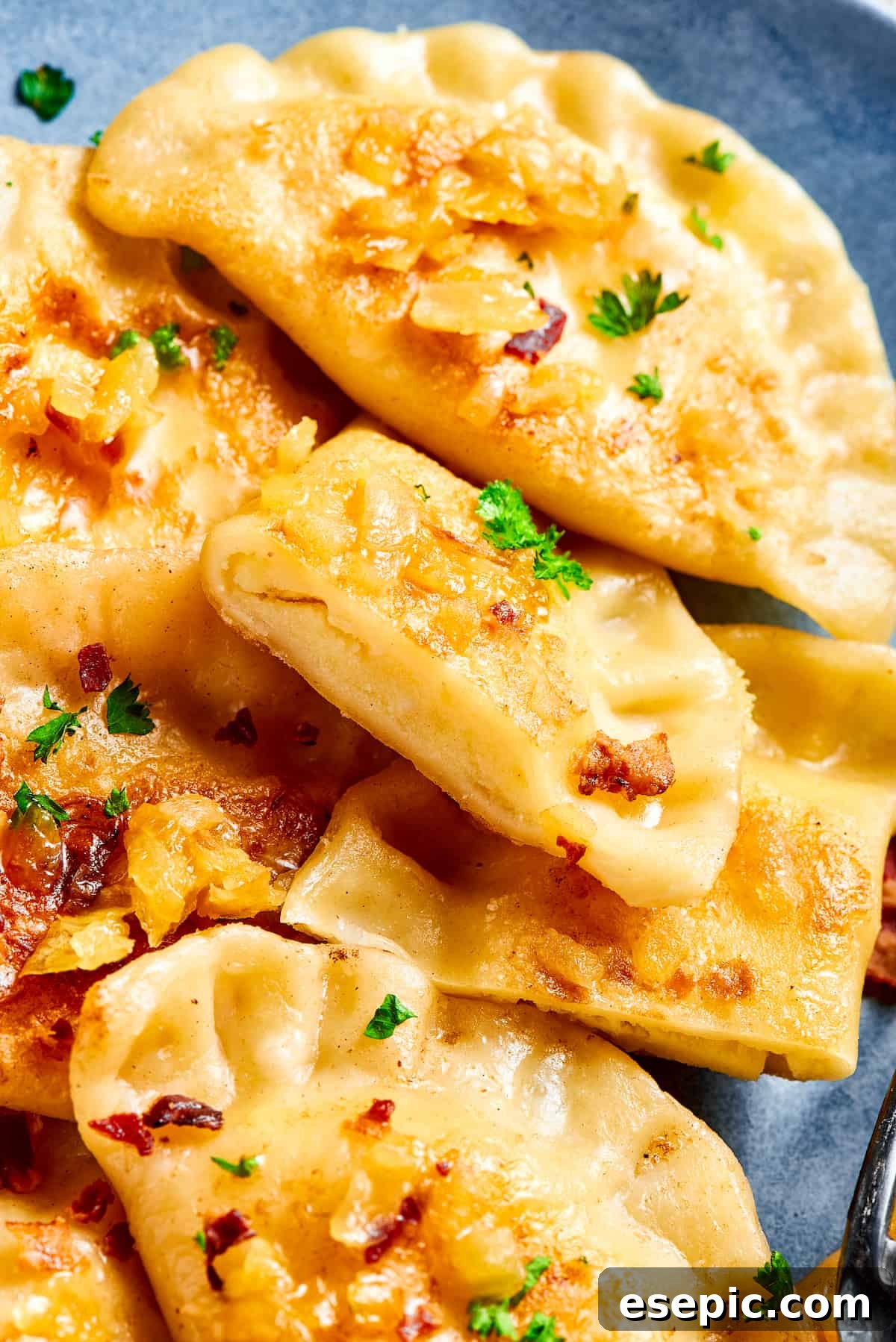 Traditional Potato and Cheese Pierogi with Onions and Bacon Topping A serving of traditional potato and cheese pierogi garnished with sautéed onions and crispy bacon, ready to be enjoyed.