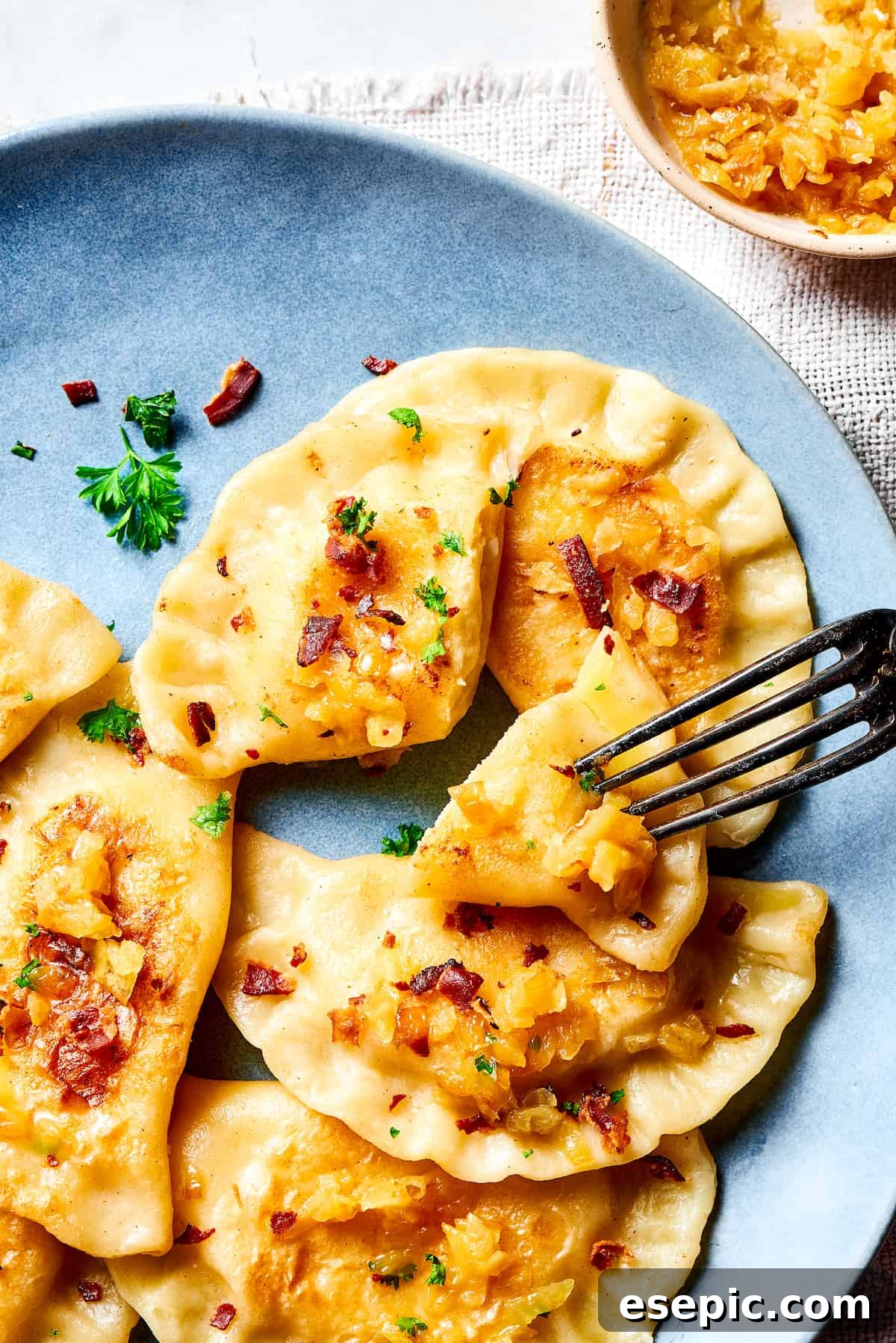 Close-up of a Pierogi Ready to Be Eaten A fork poised to pick up a bite-sized piece of a savory homemade pierogi, showcasing its appealing texture.