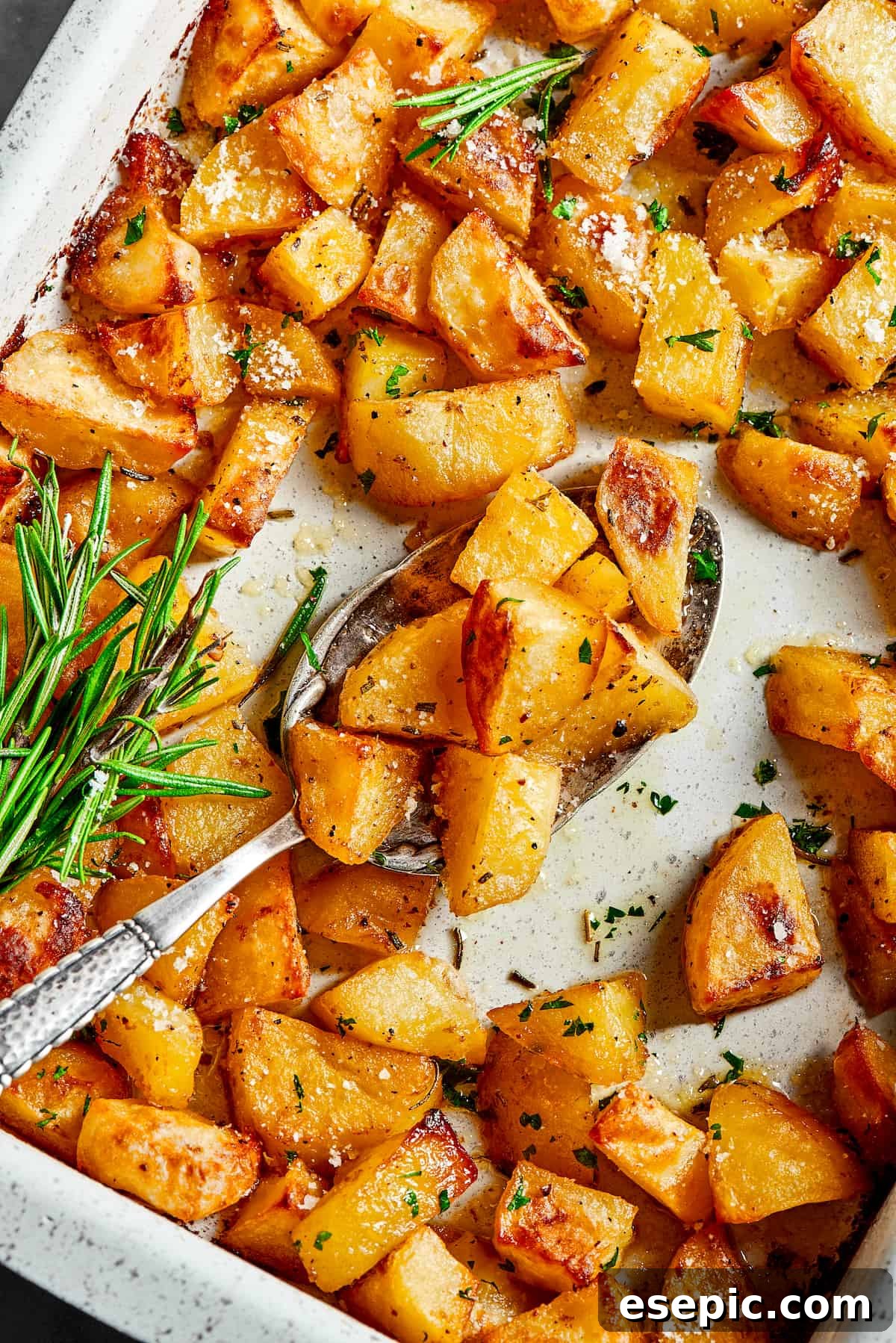 A baking dish filled with beautifully seasoned potatoes, ready for roasting.