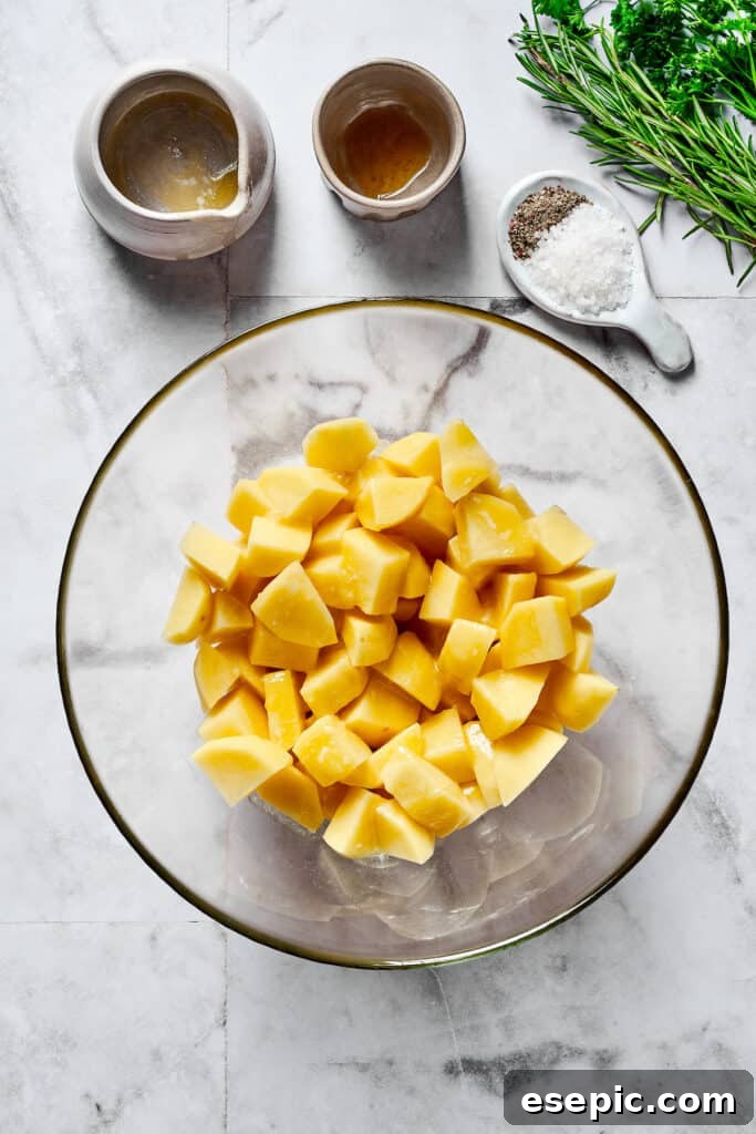 Raw, cut-up potatoes in a mixing bowl, ready for seasoning.
