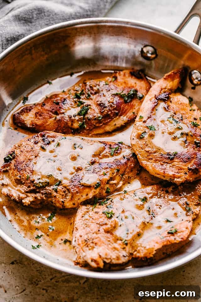 Enjoy our go-to stovetop recipe for juicy and tender balsamic chicken breasts, easily made in one pan in just 30 minutes! side view of four cooked chicken breasts topped with balsamic sauce and parsley
