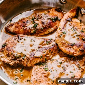 side view of four cooked chicken breasts topped with balsamic sauce and parsley