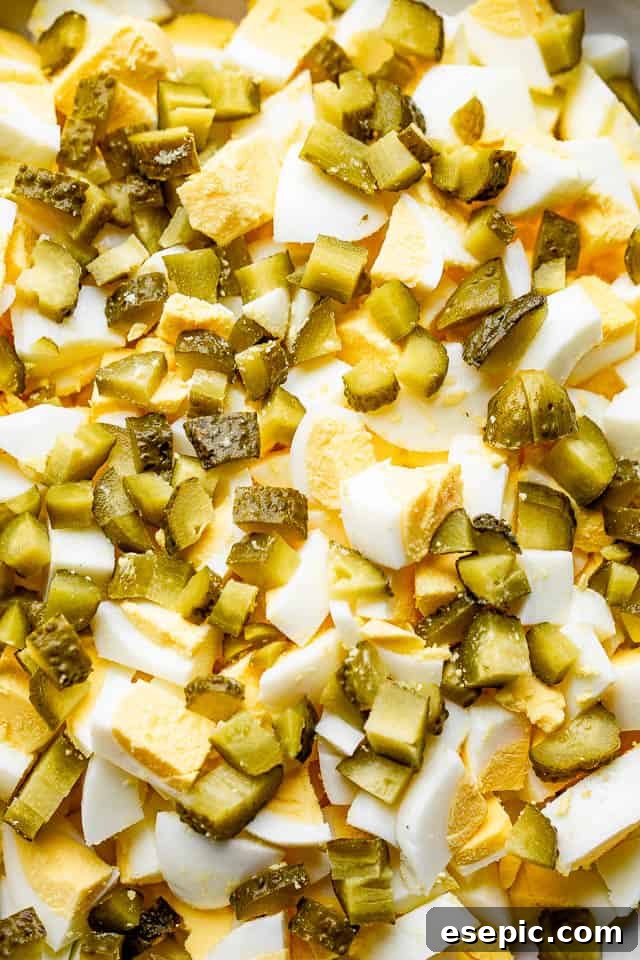 close up shot of chopped eggs and chopped pickles