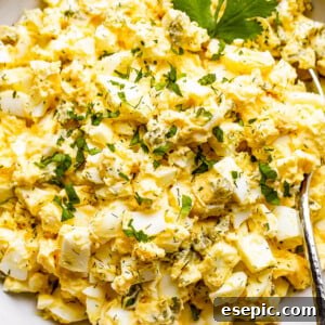 scooping out egg salad from a bowl