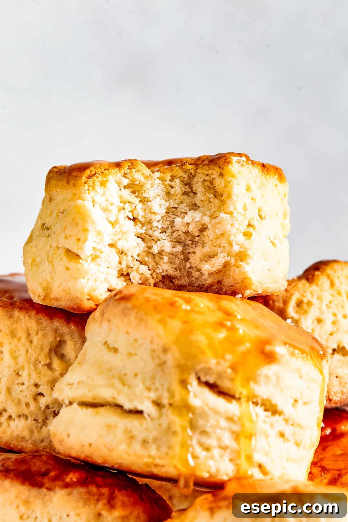 Biscuits piled onto a cake plate. One biscuit has a bite taken out of it.