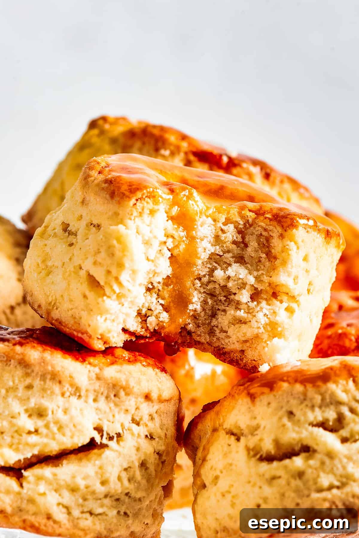 Biscuits piled onto a cake plate. One biscuit has a bite taken out of it.