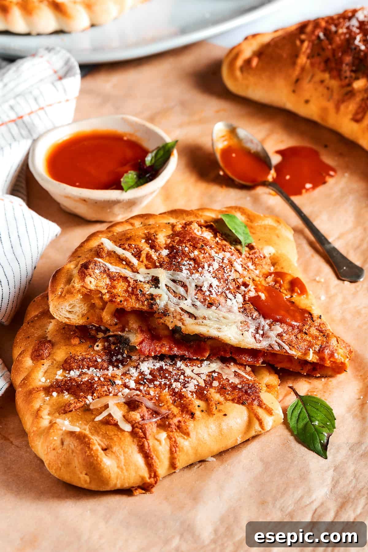 A pizza pocket cut in half to show the cheesy filling, resting on a wooden board.