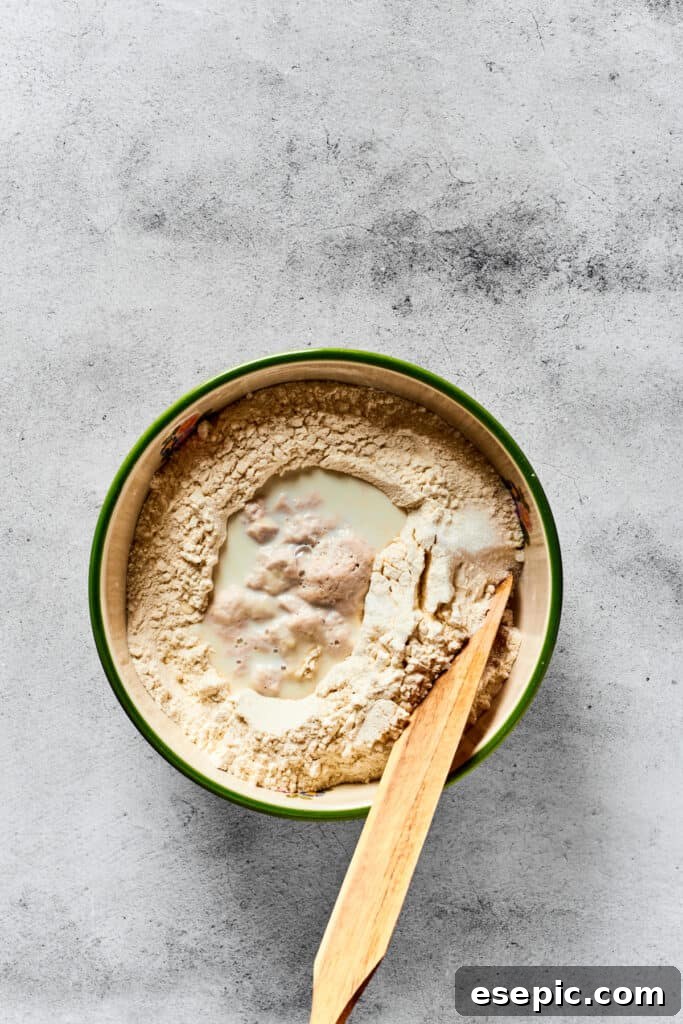 Mixing together calzone dough in a mixing bowl by hand.