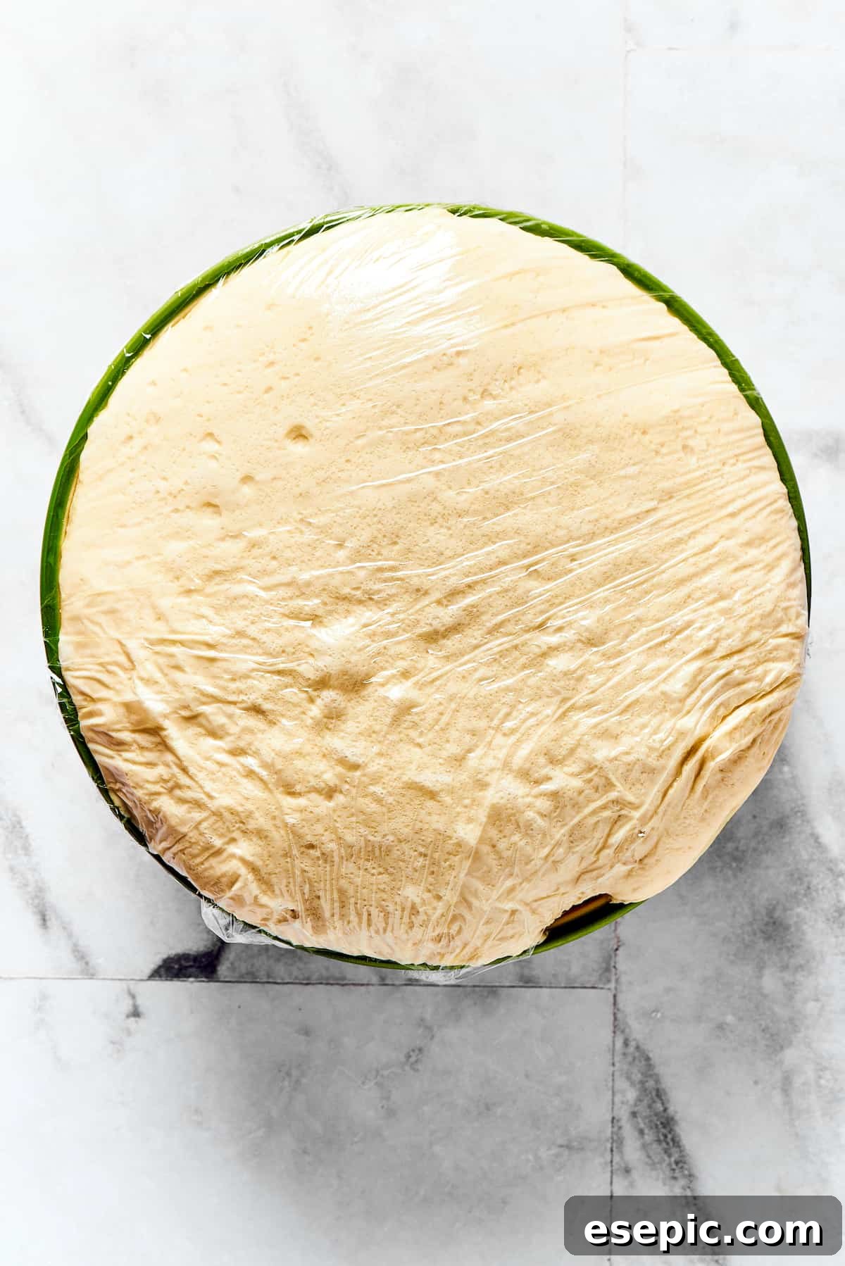 A large amount of risen dough, visibly doubled in volume, in a mixing bowl.