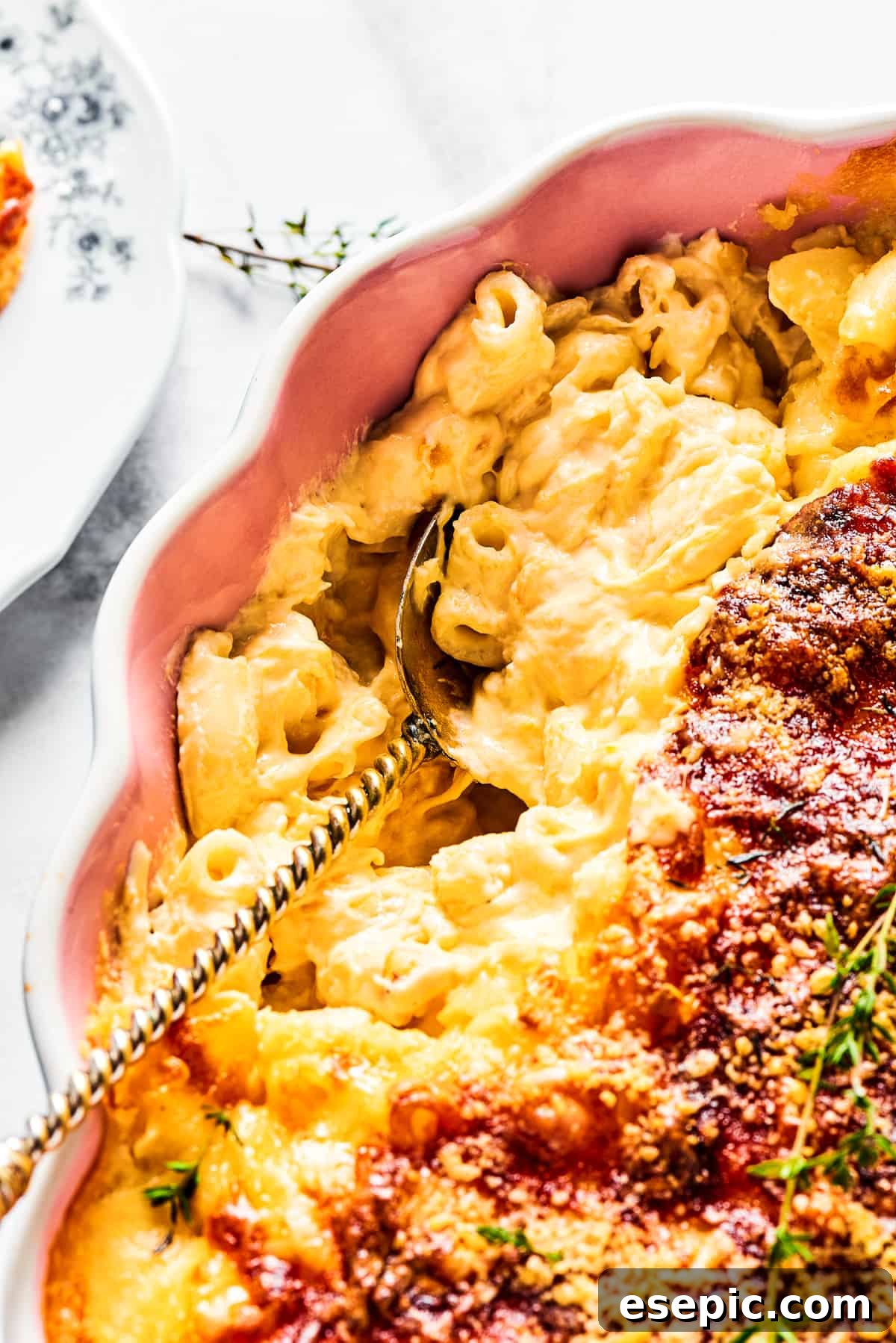 Spooning baked macaroni out of a casserole dish.