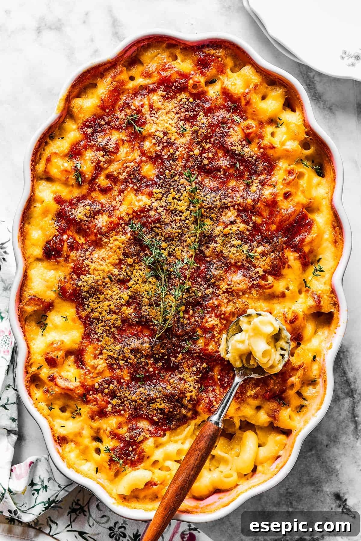 Spooning baked macaroni out of a casserole dish.
