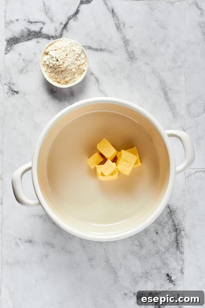 Butter melting in a Dutch oven, next to a small dish of flour.