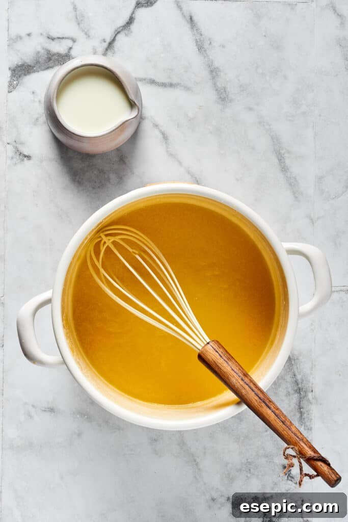 A blonde roux cooking in a pot.