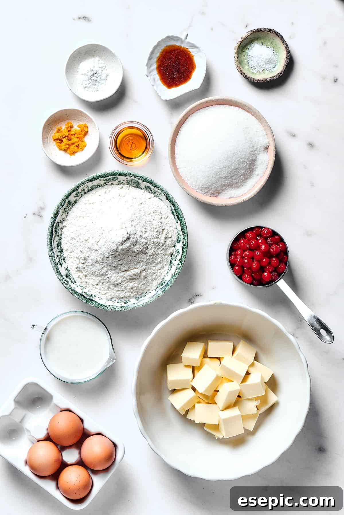 Christmas Cranberry Pound Cake is a festive holiday dessert with fresh cranberries, orange liqueur, vanilla bean paste, and a sweet glaze. A vibrant flat lay showcasing all the fresh ingredients for the cranberry pound cake: baking powder, vanilla, salt, orange zest, orange liqueur, sugar, flour, fresh cranberries, buttermilk, butter, and eggs.