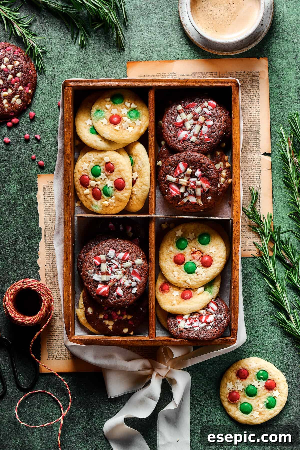 Easy vanilla and chocolate Christmas Cake Mix Cookies are studded with red and green M&Ms, and decorated with even more holiday goodies! A charming presentation of assorted Christmas cookies, divided into four sections within a decorative box, showcasing different vanilla and chocolate cake mix cookie varieties.