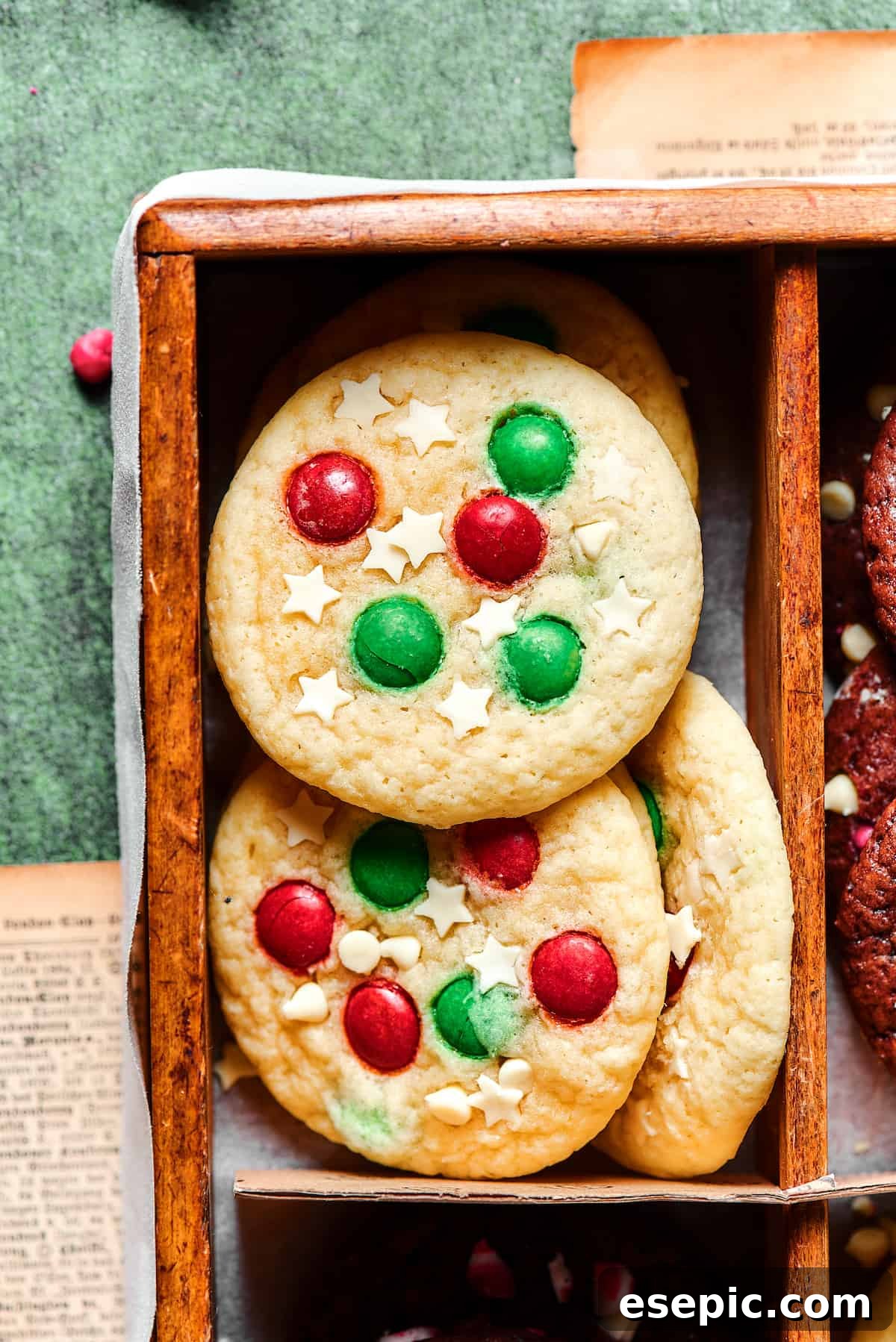Easy vanilla and chocolate Christmas Cake Mix Cookies are studded with red and green M&Ms, and decorated with even more holiday goodies! Close-up of festive sugar cookies generously decorated with vibrant red and green M&Ms and delicate white chocolate star candies.