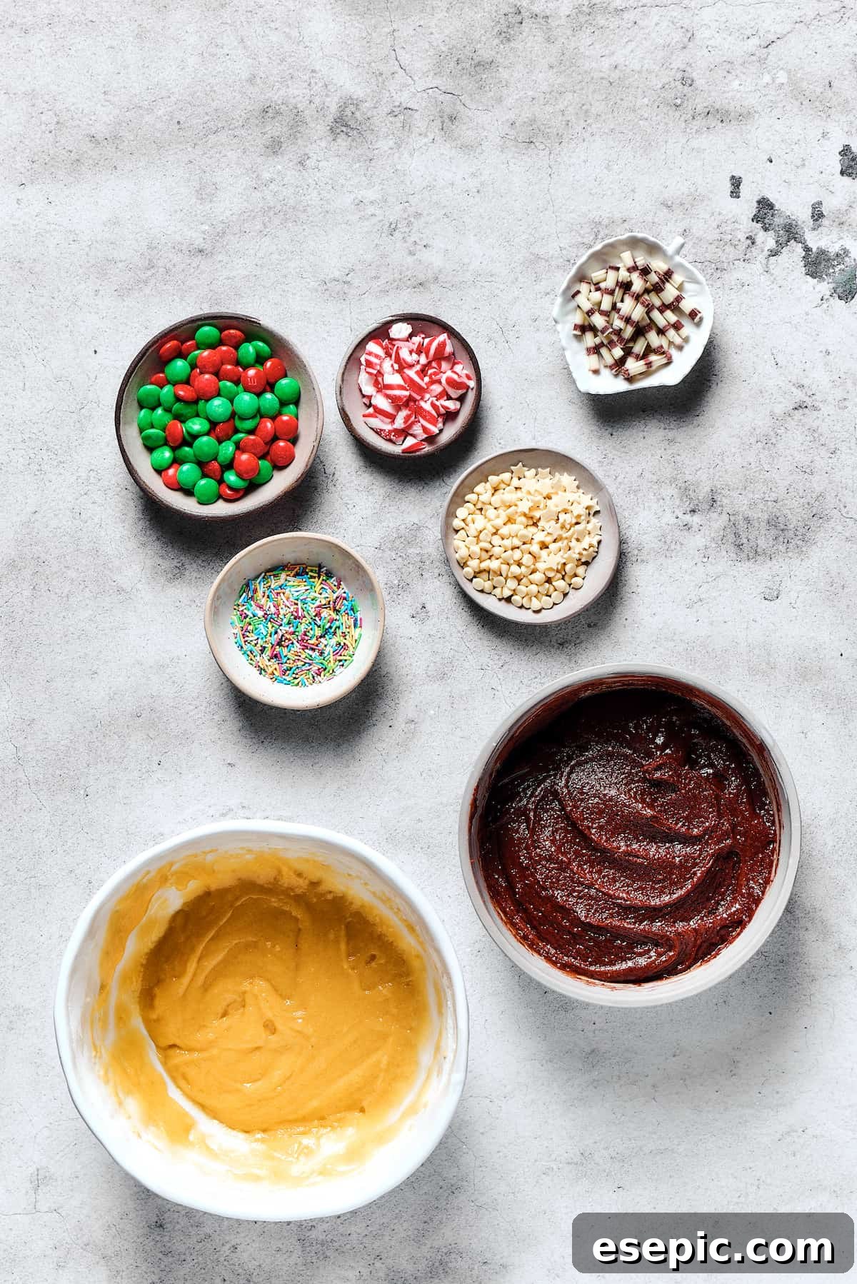 Yuletide Cake Mix Wonders 6 Two distinct bowls of cookie dough, one vanilla and one chocolate, are presented alongside an array of small dishes filled with colorful and festive cookie decorations.