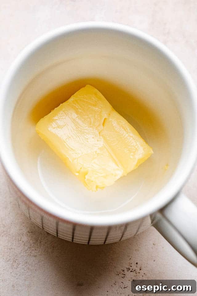 Melted butter ready in a microwave-safe mug, forming the base of the chocolate mug cake.
