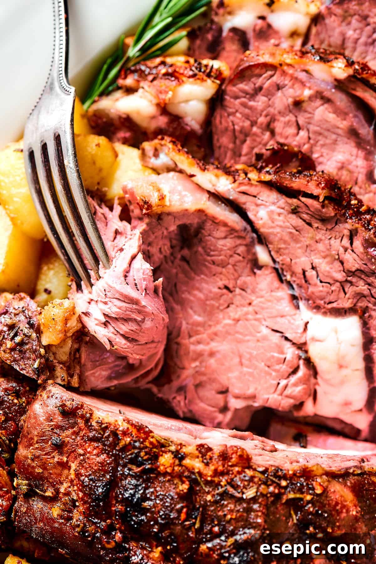 A fork lifts a succulent slice of rib roast, ready to be enjoyed.