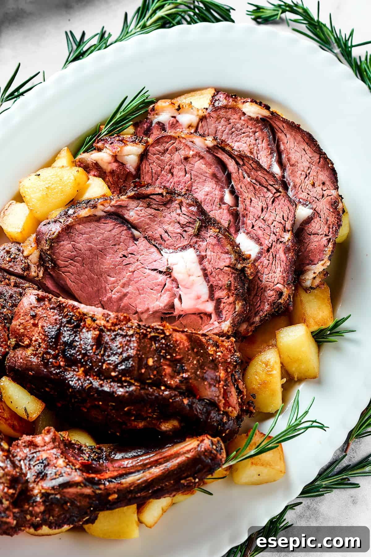 A stunning serving platter featuring slices of standing rib roast, artfully arranged with golden roasted potatoes and fresh herbs.
