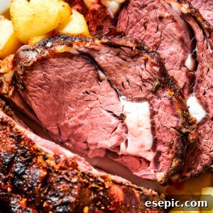Close-up shot of prime rib, sliced and garnished with herbs.
