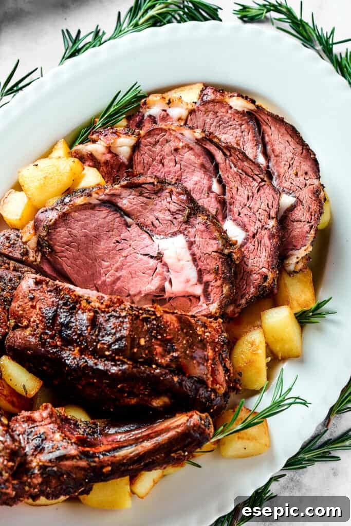 A generously sliced standing rib roast presented on a serving platter, adorned with roasted potatoes and fresh herbs.