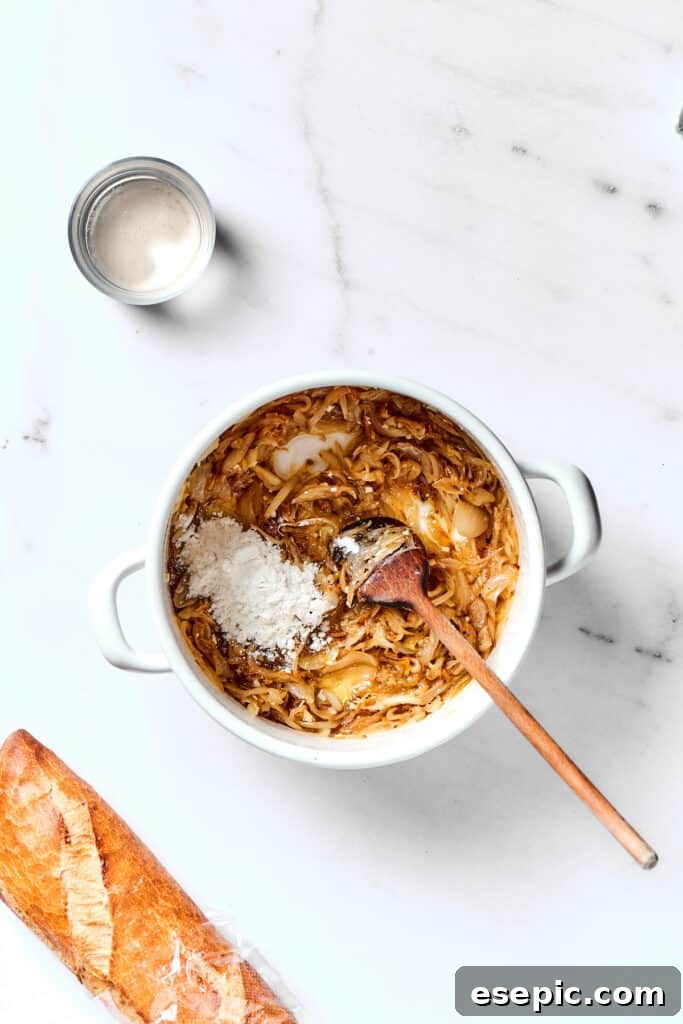 French Onion Soup broth simmering in a heavy pot with bay leaves and fresh thyme sprigs, releasing aromatic steam as it cooks.