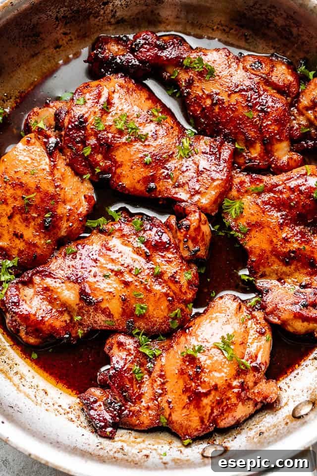 Golden-brown pan-seared Cajun butter chicken thighs in a cast iron skillet, ready to be served.