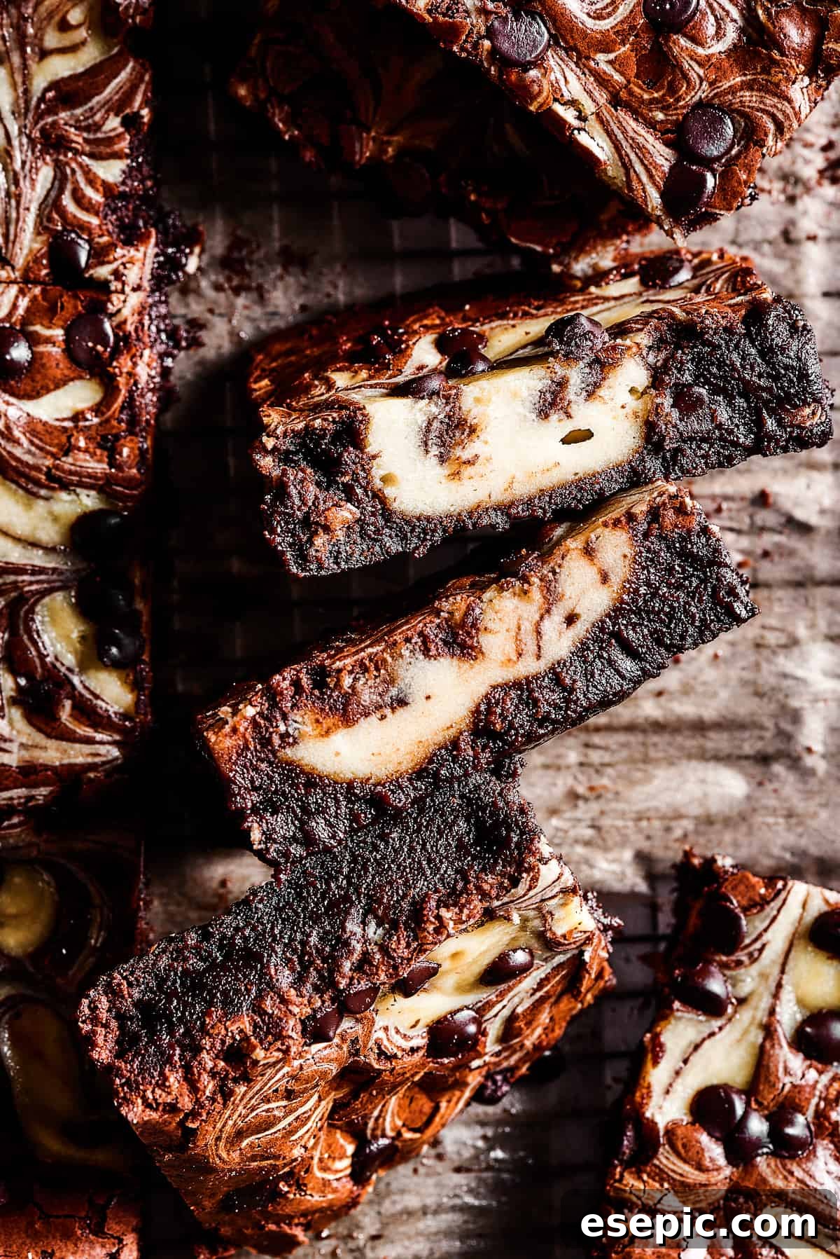 Side view of brownies with cream cheese filling swirled through, showing distinct layers.
