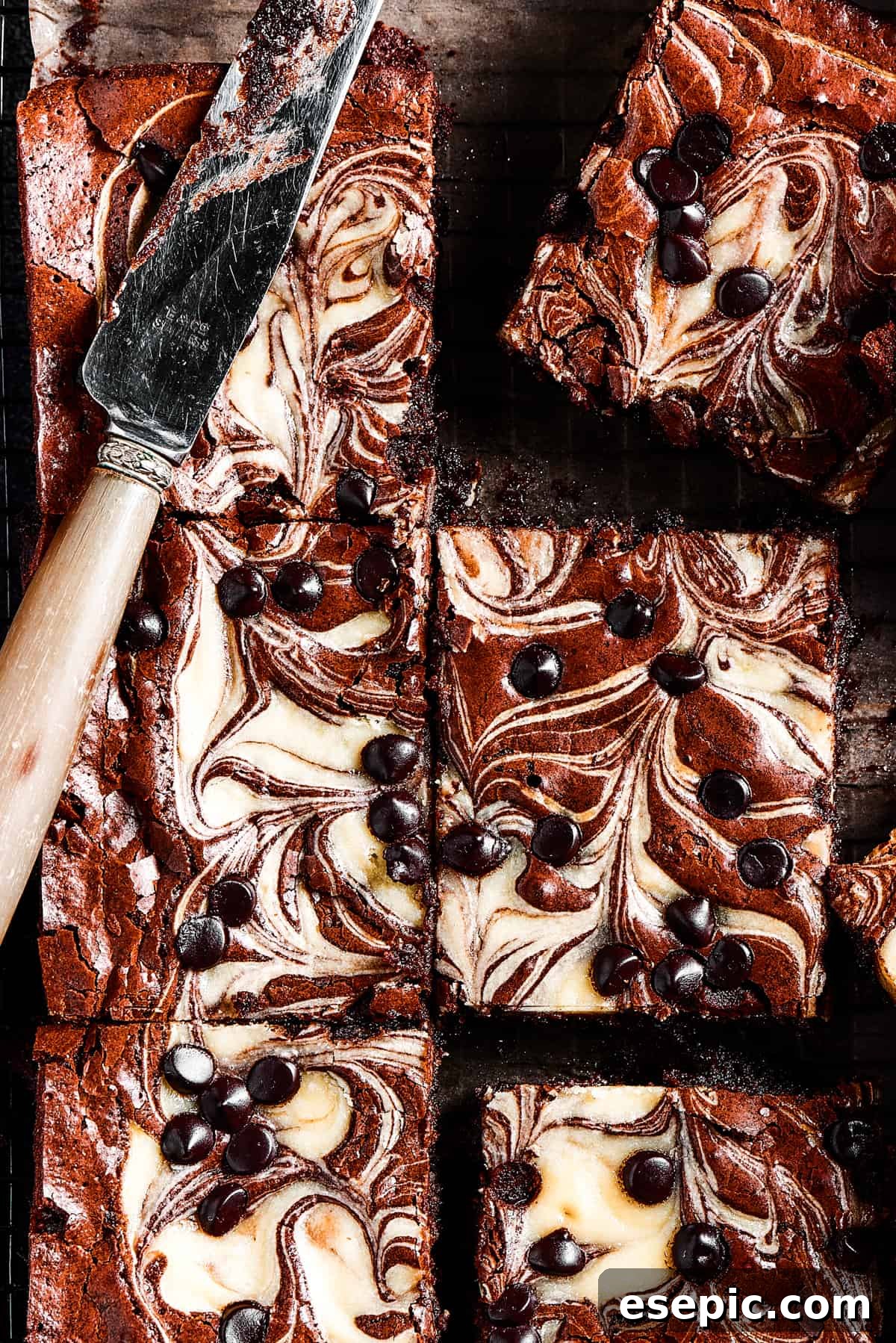 Overhead shot of cream cheese swirl brownies dotted with chocolate chips, ready to be stored or served.