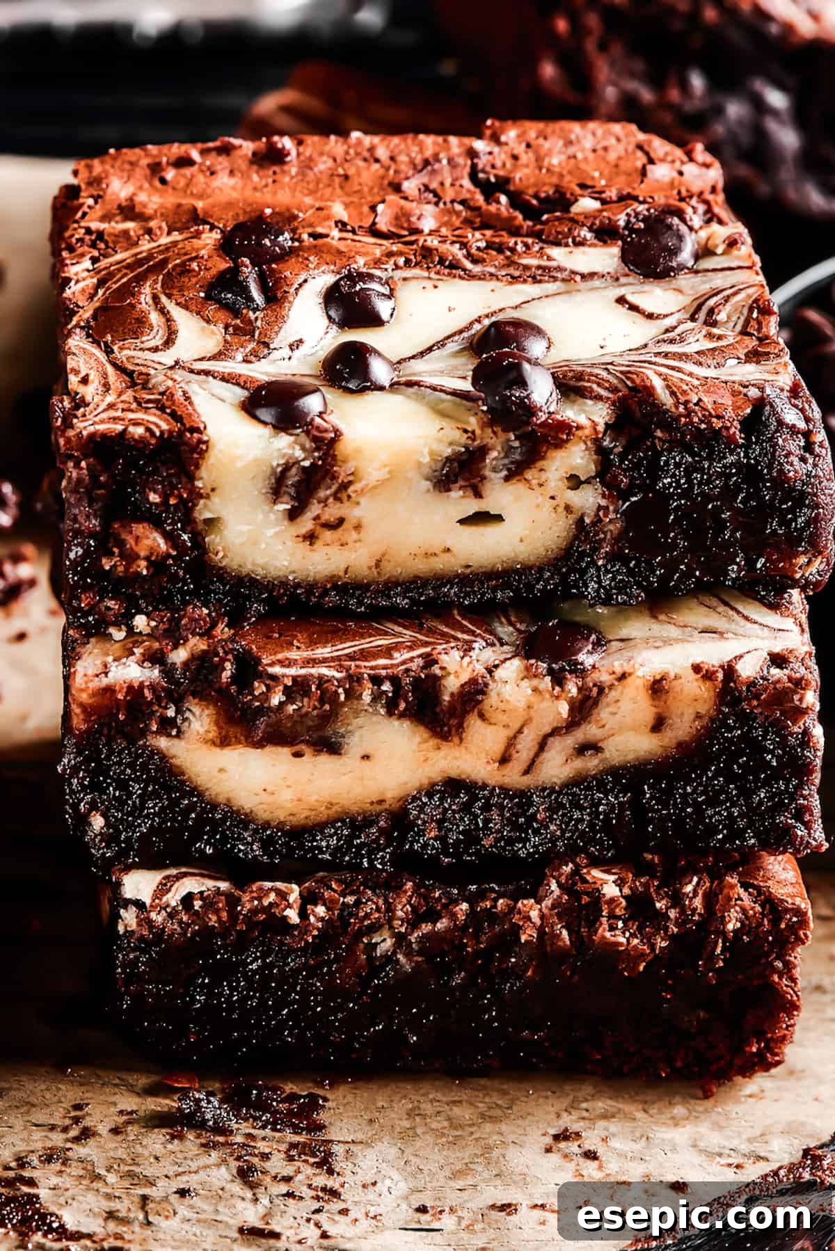 Three cream cheese brownies stacked on a wire rack, showcasing their layers and swirl.